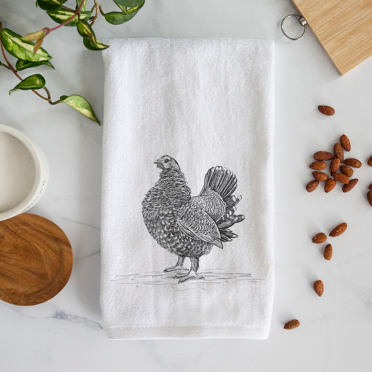 White hand towel printed with a detailed black ink illustration of a spruce grouse standing with its tail fanned.