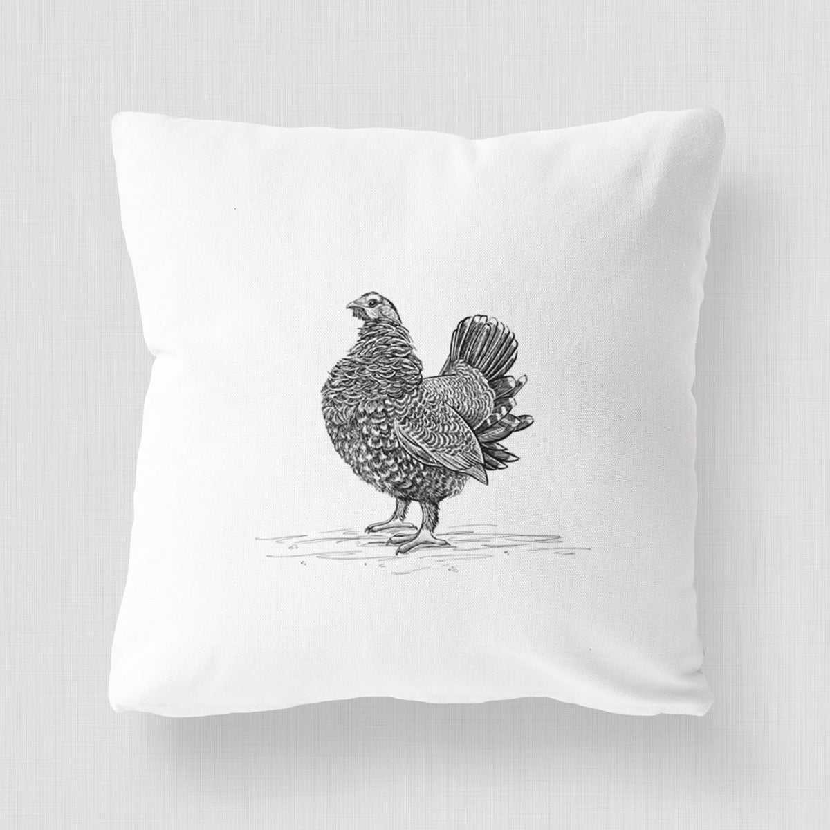 White pillow cover printed with a detailed black ink illustration of a spruce grouse standing with its tail fanned.