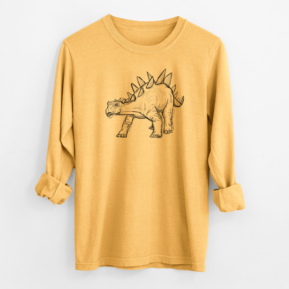 Golden wheat yellow Comfort Colors long sleeve shirt laid flat with the cuffs rolled, printed with a black ink illustration of a Stegosaurus with plates along its back.