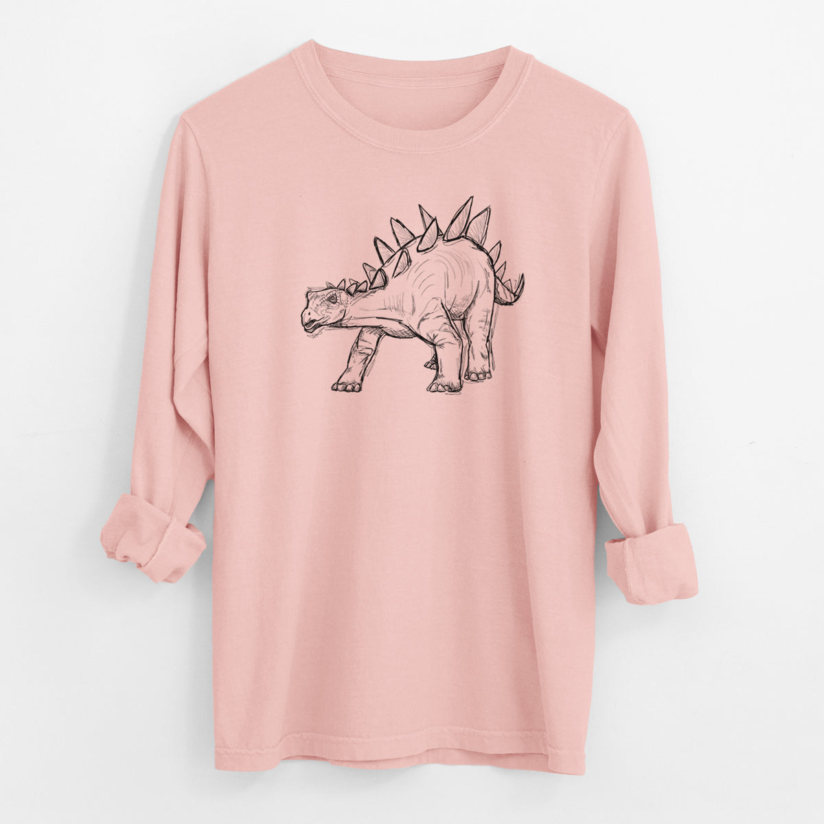 Peachy Comfort Colors long sleeve shirt laid flat with the cuffs rolled, printed with a black ink illustration of a Stegosaurus with plates along its back.