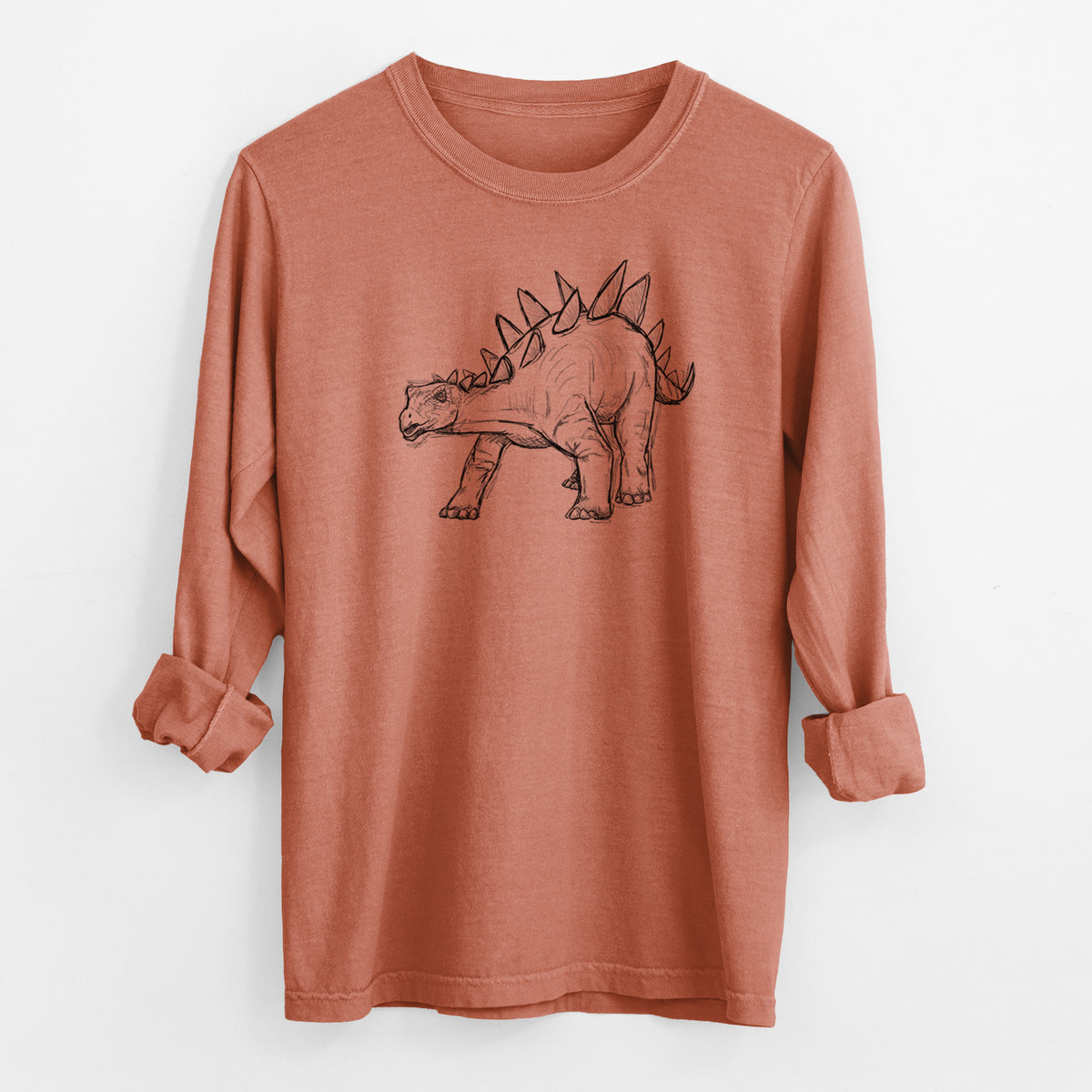 Yam burnt orange Comfort Colors long sleeve shirt laid flat with the cuffs rolled, printed with a black ink illustration of a Stegosaurus with plates along its back.