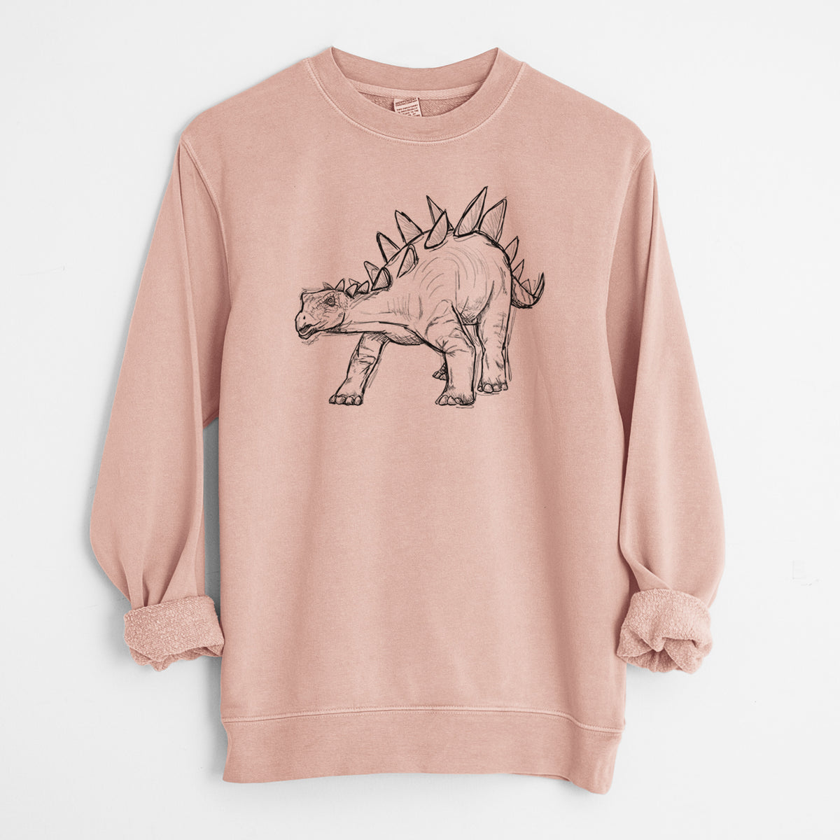 Dusty pink pigment dyed crewneck sweatshirt laid flat with the sleeves rolled, printed with a black ink illustration of a Stegosaurus with plates along its back.