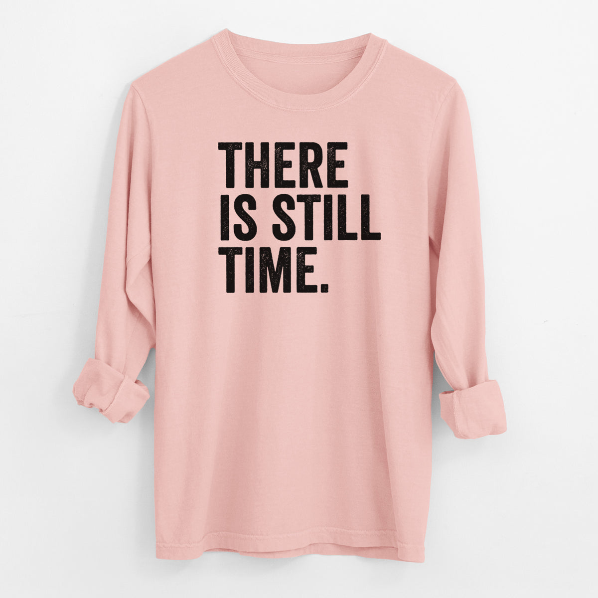 Peachy Comfort Colors long sleeve shirt laid flat with the cuffs rolled, printed with bold black words reading There Is Still Time.