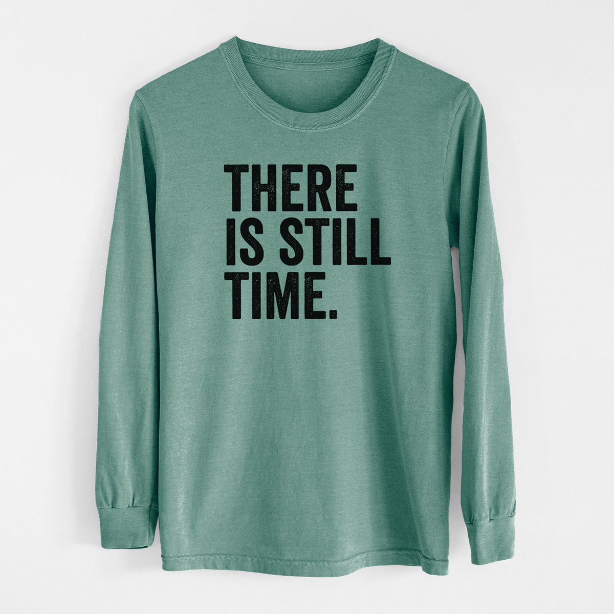 Pine green Comfort Colors long sleeve shirt laid flat, printed with bold black words reading There Is Still Time.