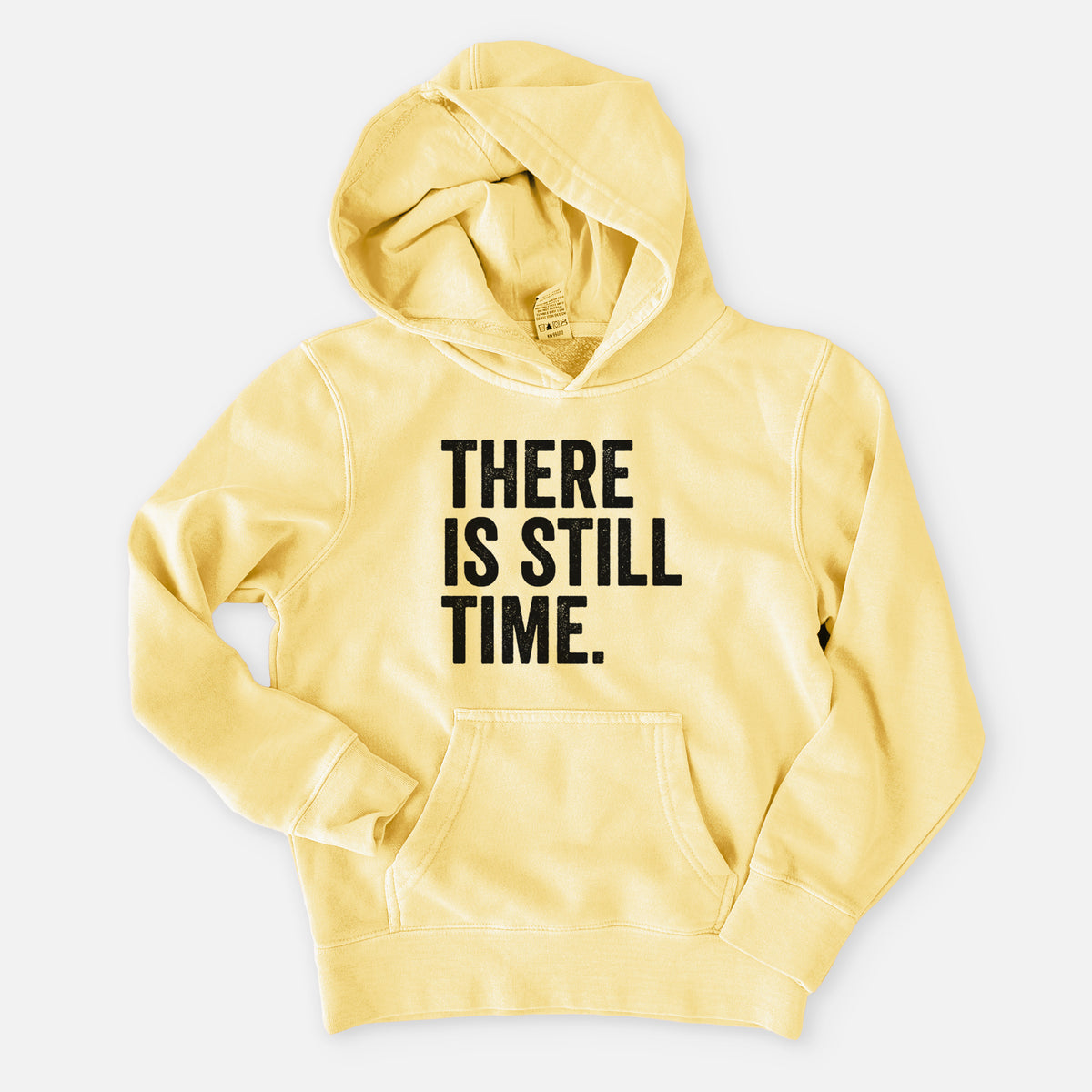 Pigment yellow youth pigment dyed hoodie laid flat, printed with bold black words reading There Is Still Time.