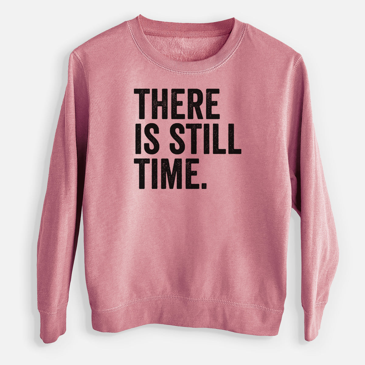 Mauve pink youth crewneck sweatshirt laid flat, printed with bold black words reading There Is Still Time.