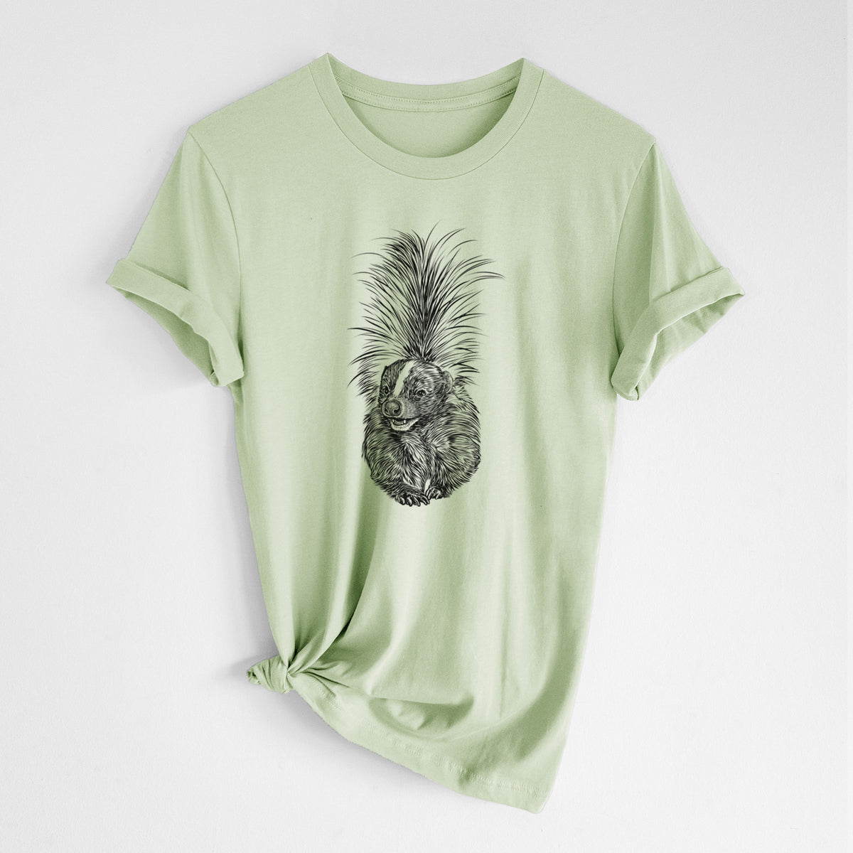 Spring green lightweight cotton t-shirt laid flat with the sleeves rolled, printed with a detailed black ink illustration of a striped skunk with its tail raised.