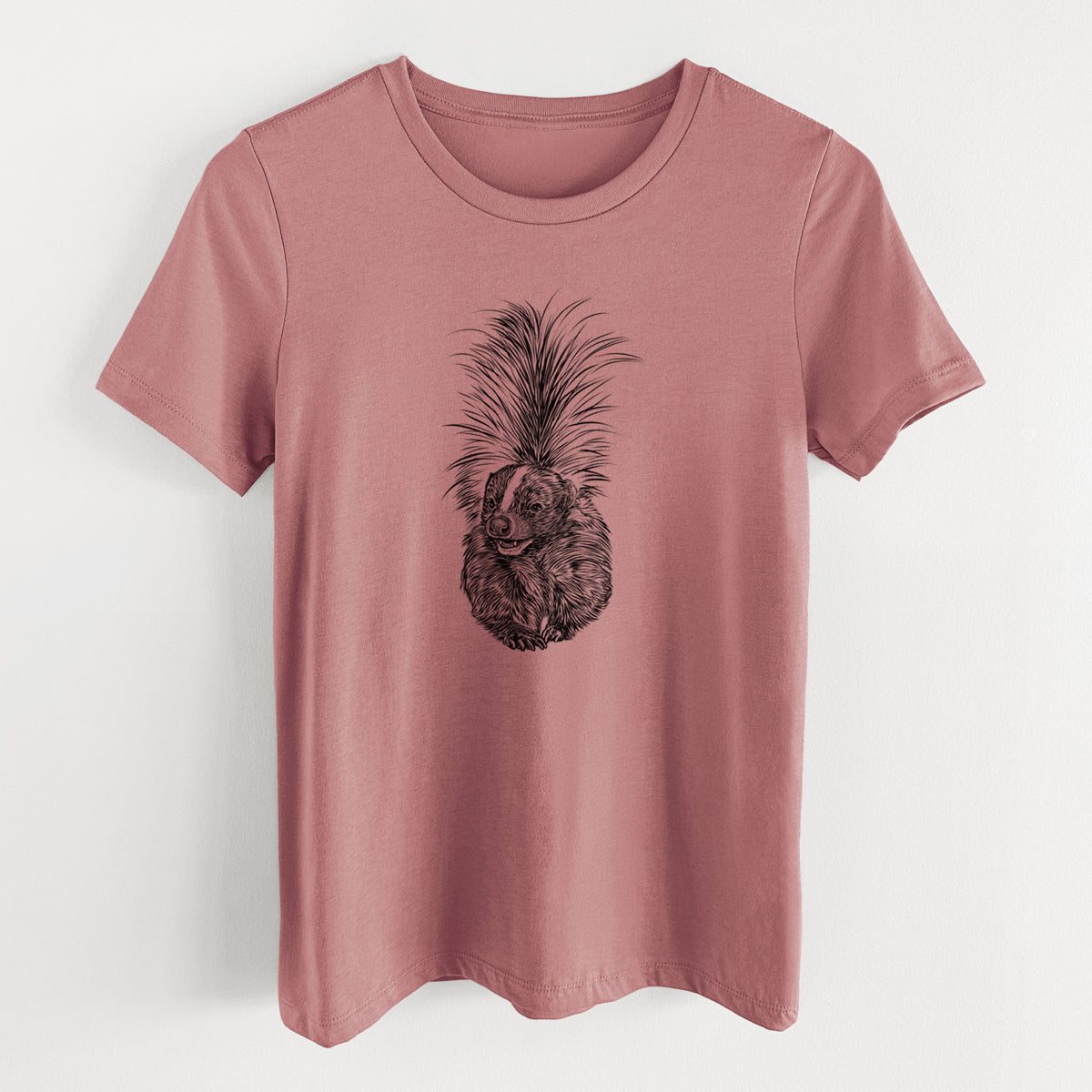 Mauve pink women's relaxed fit cotton t-shirt laid flat, printed with a detailed black ink illustration of a striped skunk with its tail raised.