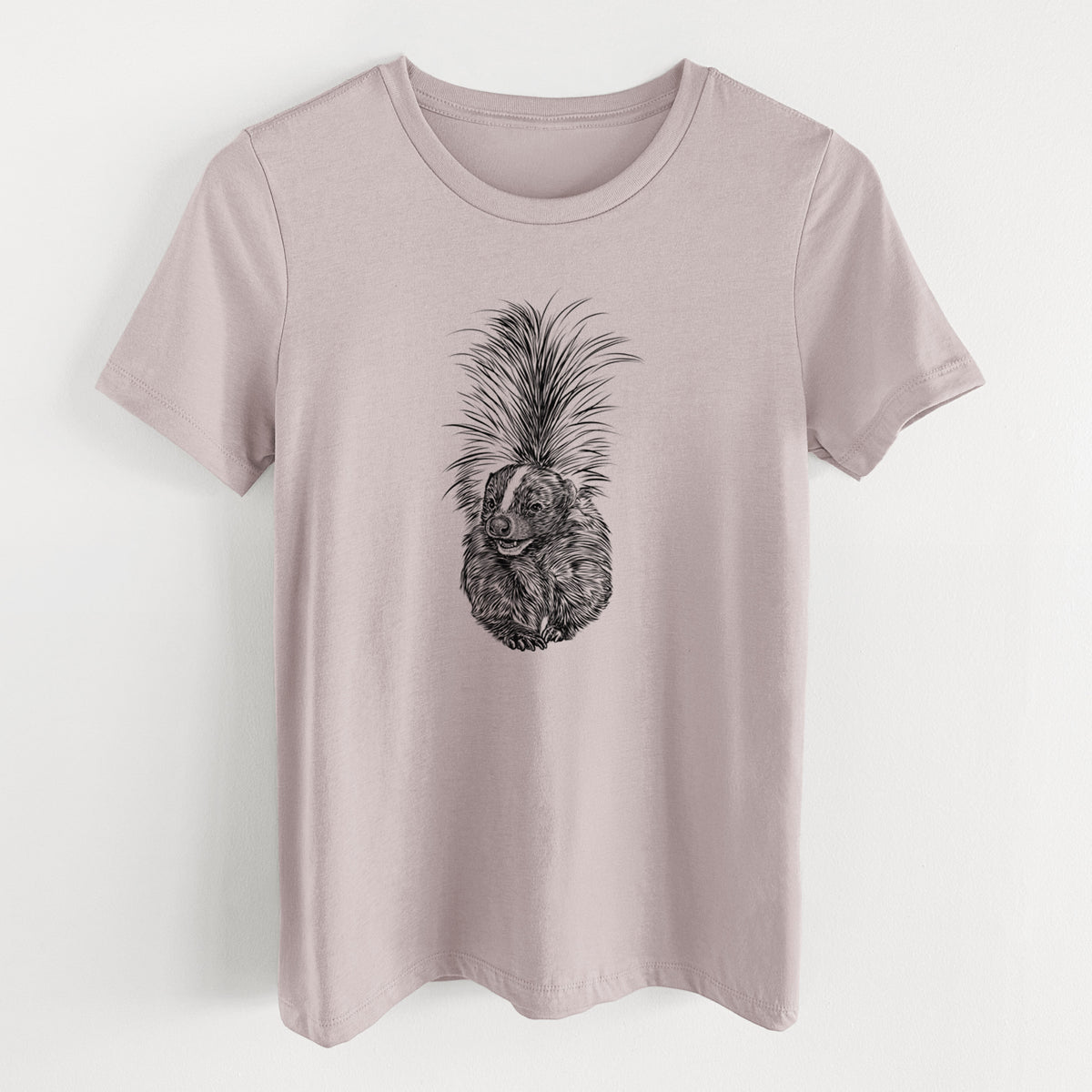 Pink gravel women's relaxed fit cotton t-shirt laid flat, printed with a detailed black ink illustration of a striped skunk with its tail raised.