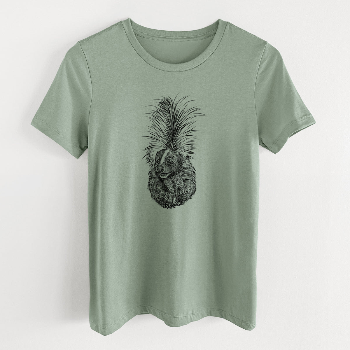 Sage green women's relaxed fit cotton t-shirt laid flat, printed with a detailed black ink illustration of a striped skunk with its tail raised.