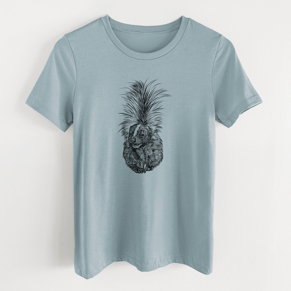 Vintage denim women's relaxed fit cotton t-shirt laid flat, printed with a detailed black ink illustration of a striped skunk with its tail raised.