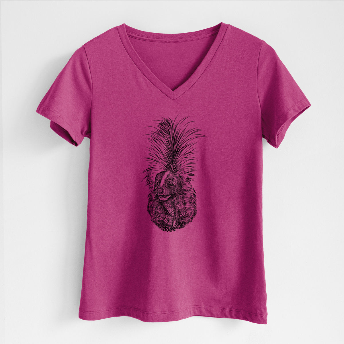 Berry pink women's relaxed fit cotton V-neck t-shirt laid flat, printed with a detailed black ink illustration of a striped skunk with its tail raised.