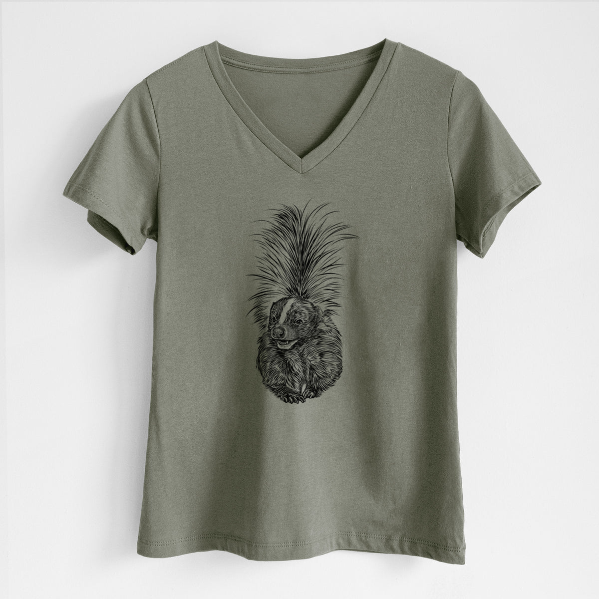 Military green women's relaxed fit cotton V-neck t-shirt laid flat, printed with a detailed black ink illustration of a striped skunk with its tail raised.