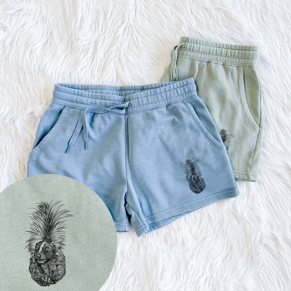 Two pairs of Cali Wave shorts in different colors printed with a detailed black ink illustration of a striped skunk with its tail raised, with a close-up of the print.