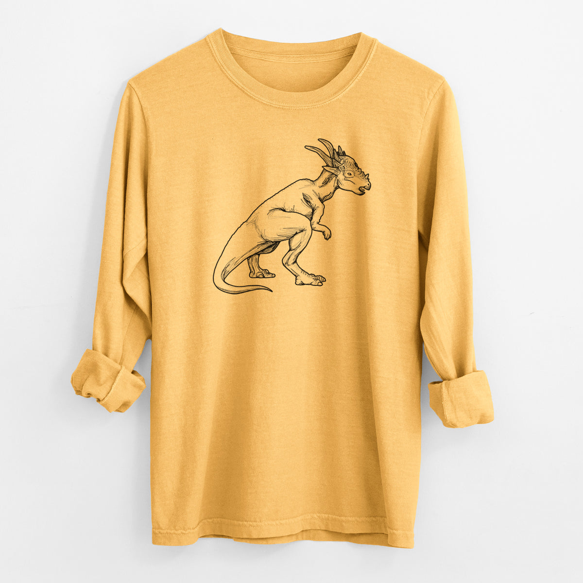 Golden wheat yellow Comfort Colors long sleeve shirt laid flat with the cuffs rolled, printed with a black ink illustration of a Stygimoloch dinosaur with a spiky domed head.