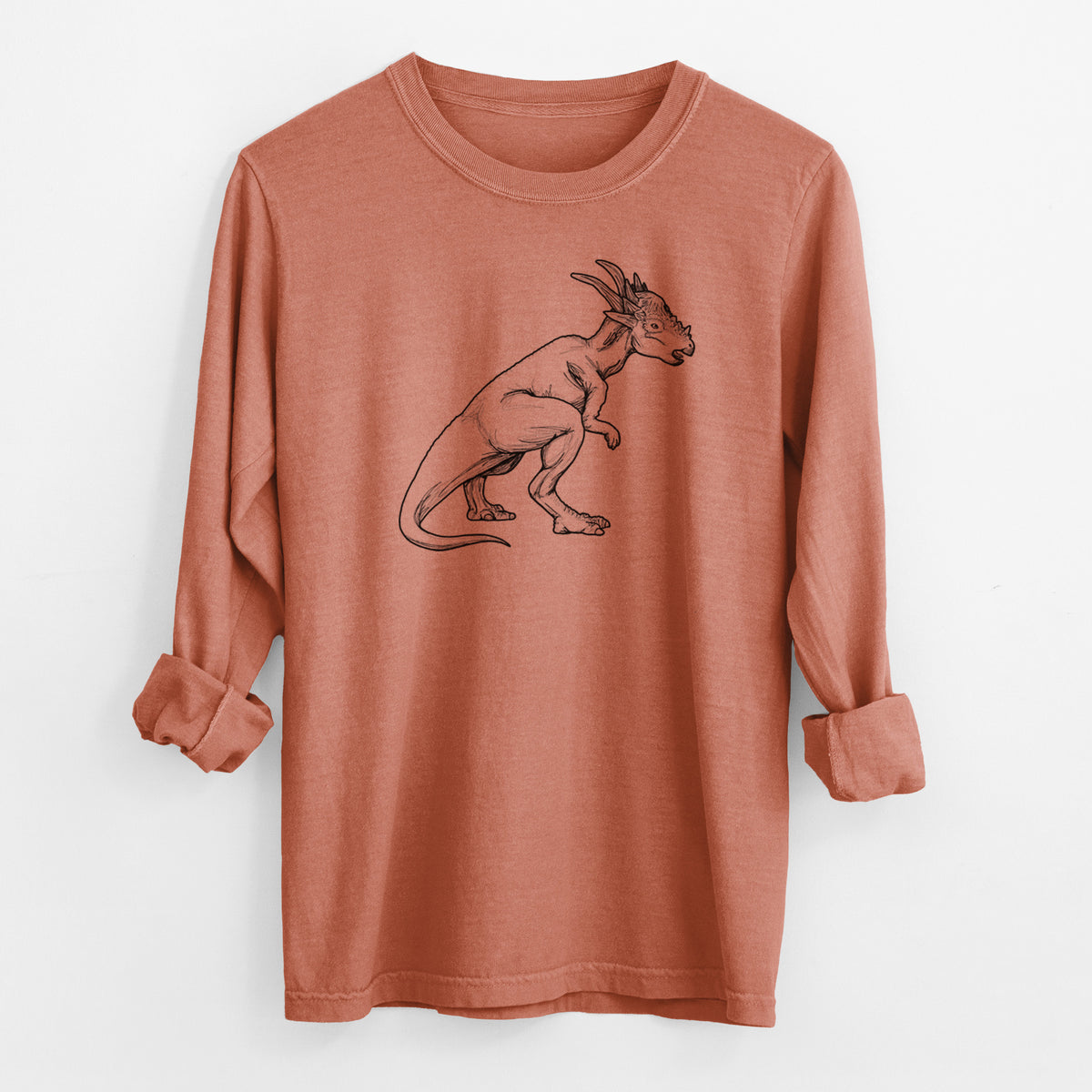 Yam burnt orange Comfort Colors long sleeve shirt laid flat with the cuffs rolled, printed with a black ink illustration of a Stygimoloch dinosaur with a spiky domed head.