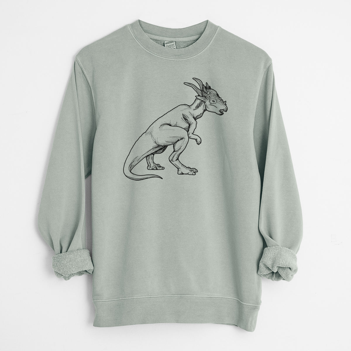 Sage green pigment dyed crewneck sweatshirt laid flat with the sleeves rolled, printed with a black ink illustration of a Stygimoloch dinosaur with a spiky domed head.