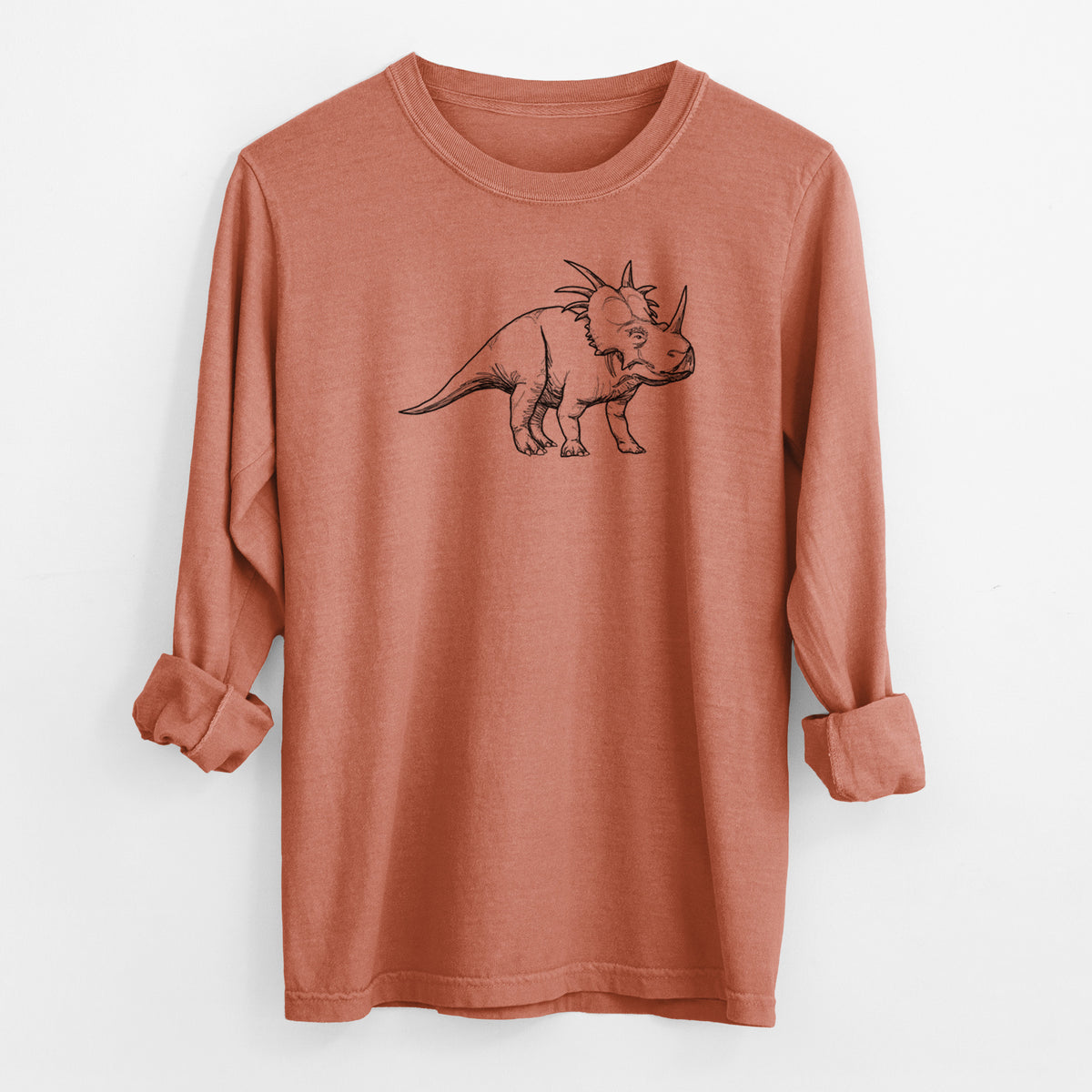 Yam burnt orange Comfort Colors long sleeve shirt laid flat with the cuffs rolled, printed with a black ink illustration of a Styracosaurus with its spiked frill.