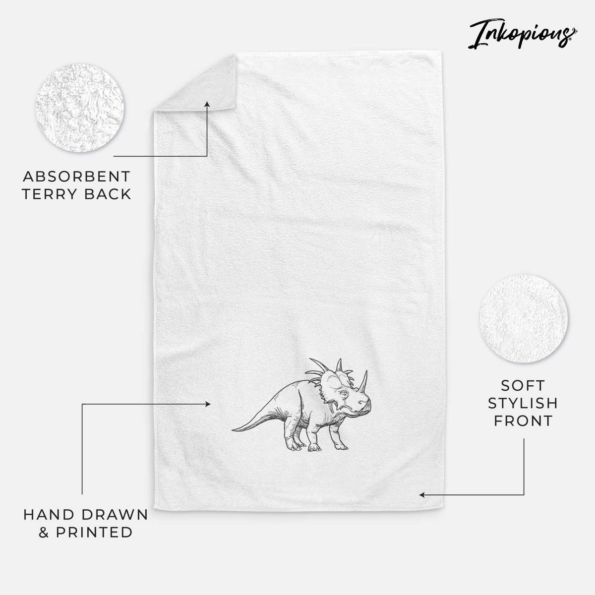 White hand towel printed with a black ink illustration of a Styracosaurus with its spiked frill.