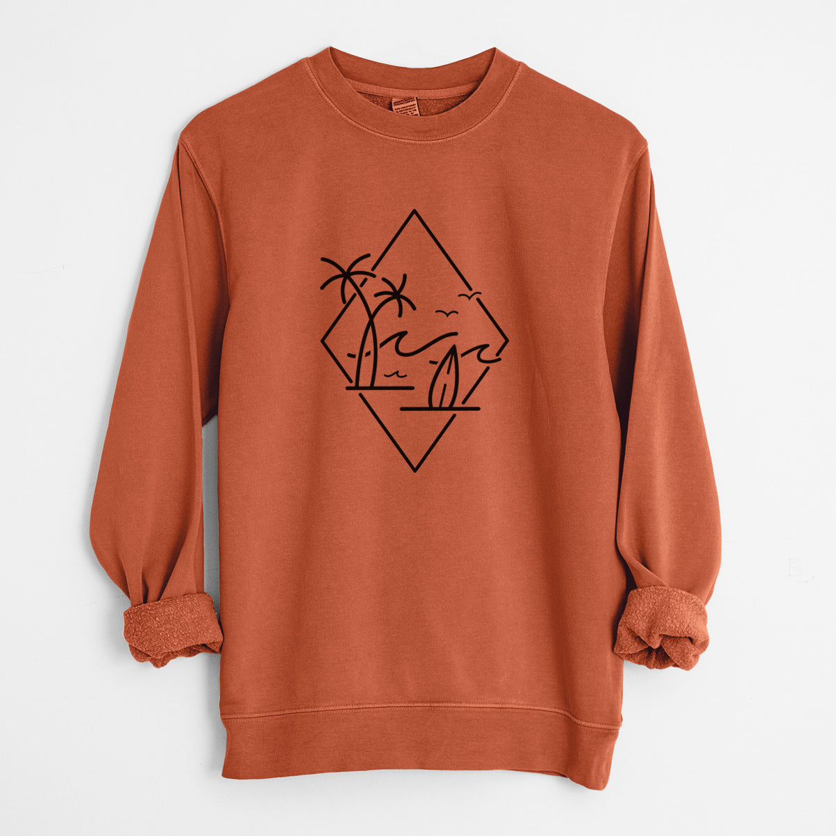 Amber orange pigment dyed crewneck sweatshirt laid flat with the sleeves rolled, printed with black line art of palm trees, ocean waves, birds and a surfboard inside a diamond outline.