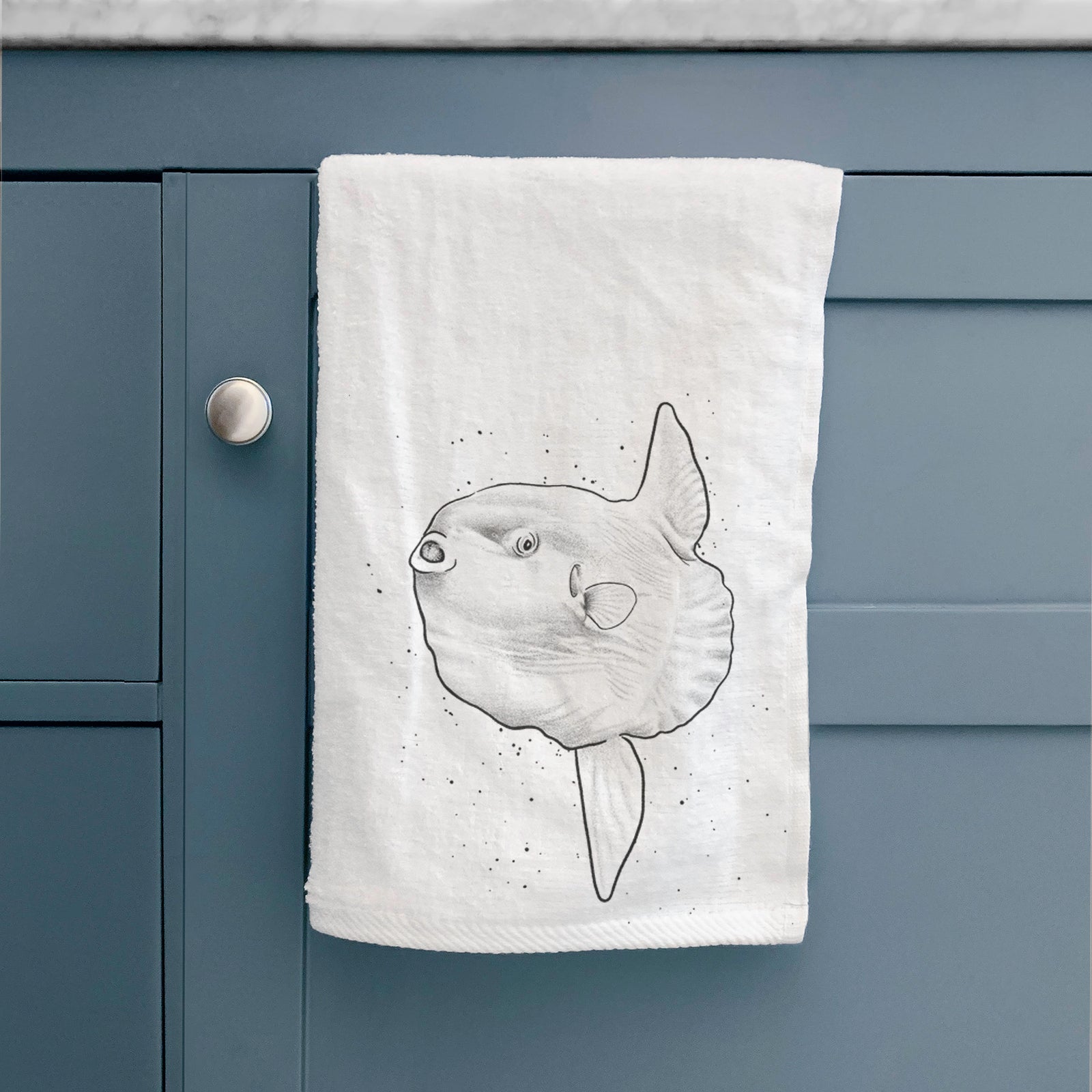 White hand towel printed with a black ink illustration of an ocean sunfish swimming.
