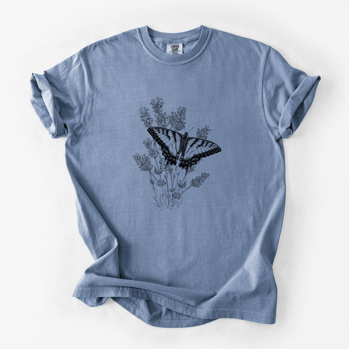 Blue jean Comfort Colors t-shirt laid flat, printed with a black ink illustration of a swallowtail butterfly resting on lavender.