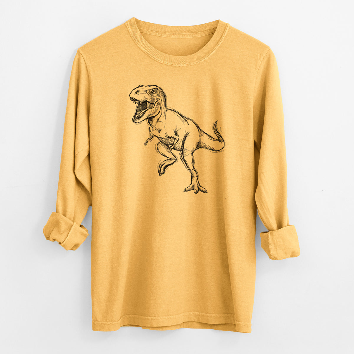 Golden wheat yellow Comfort Colors long sleeve shirt laid flat with the cuffs rolled, printed with a black ink illustration of a Tyrannosaurus rex roaring.