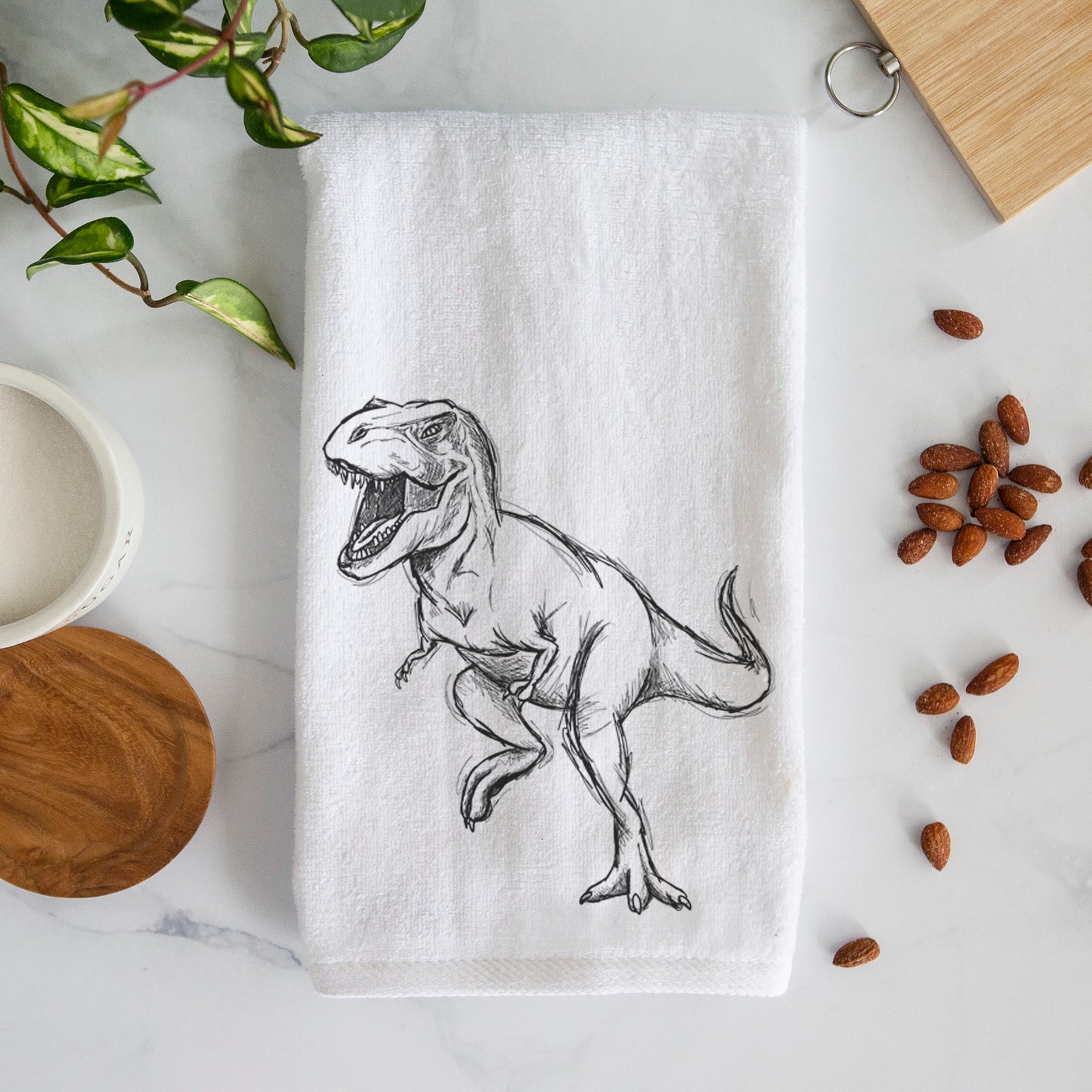 White hand towel printed with a black ink illustration of a Tyrannosaurus rex roaring.