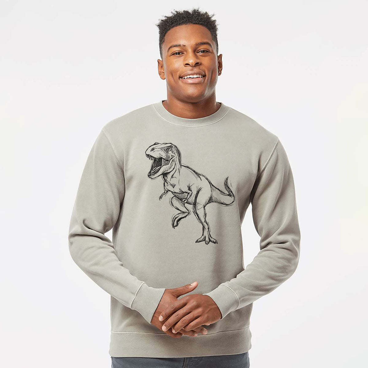 Model wearing a cement grey pigment dyed crewneck sweatshirt printed with a black ink illustration of a Tyrannosaurus rex roaring.