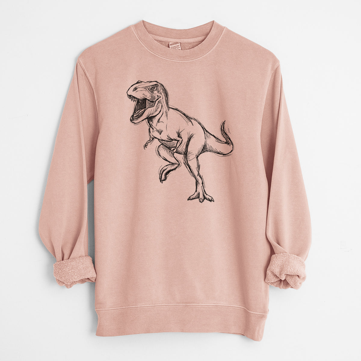 Dusty pink pigment dyed crewneck sweatshirt laid flat with the sleeves rolled, printed with a black ink illustration of a Tyrannosaurus rex roaring.