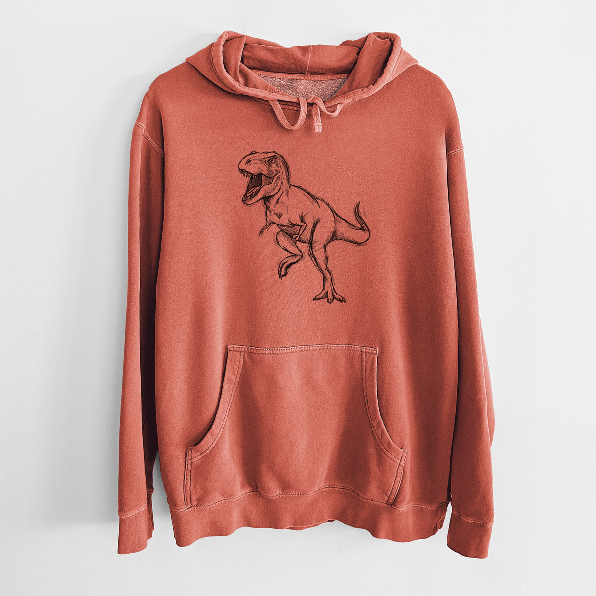 Amber orange pigment dyed hoodie laid flat, printed with a black ink illustration of a Tyrannosaurus rex roaring.