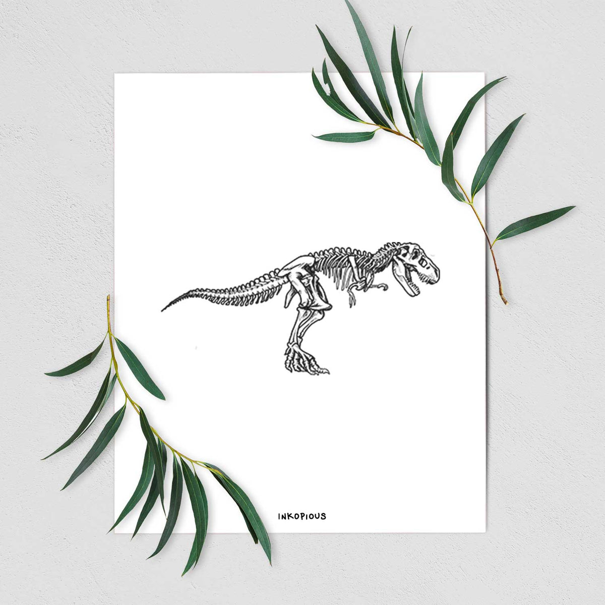 Art print of a black ink illustration of a Tyrannosaurus rex skeleton, shown with eucalyptus leaves.