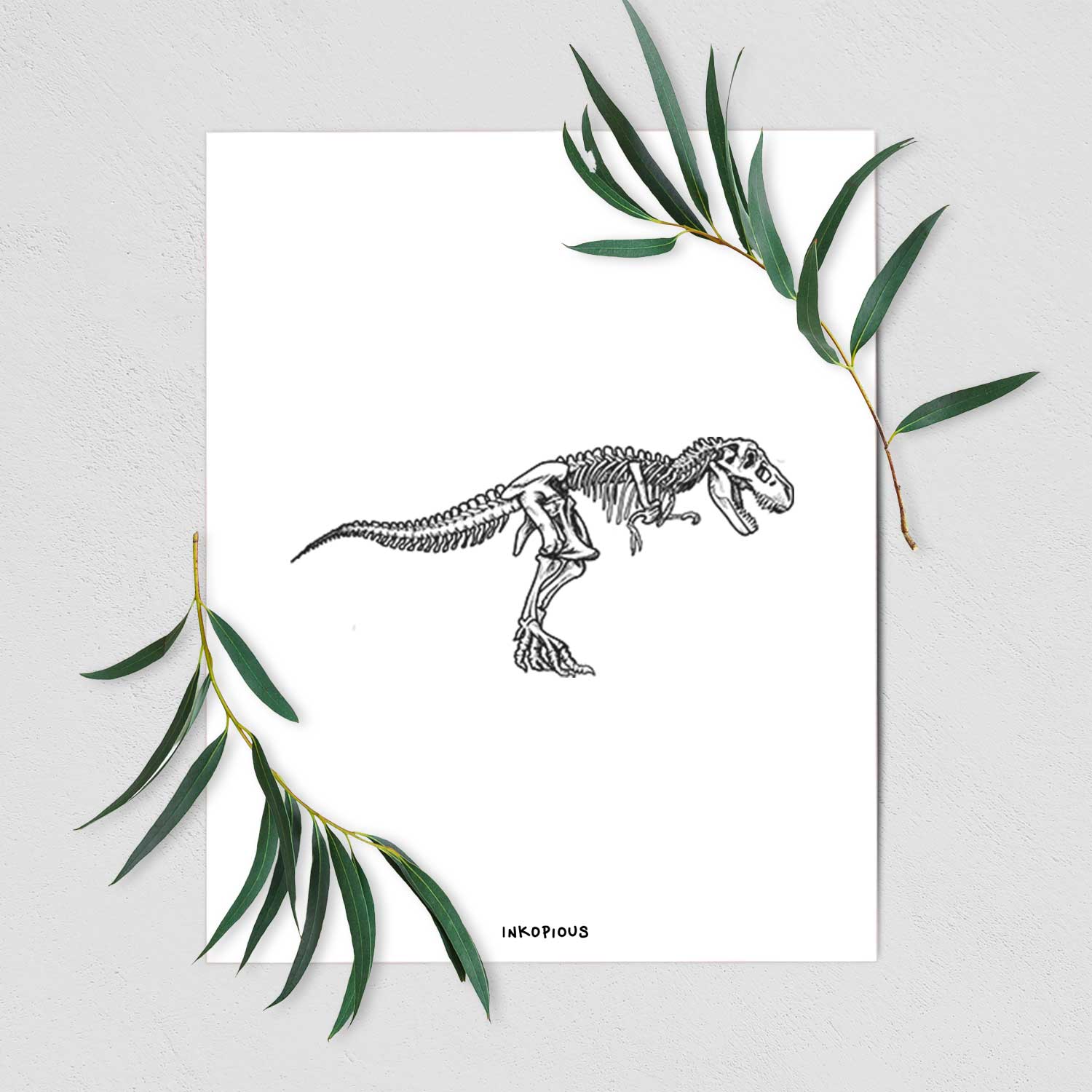 Art print of a black ink illustration of a Tyrannosaurus rex skeleton, shown with eucalyptus leaves.