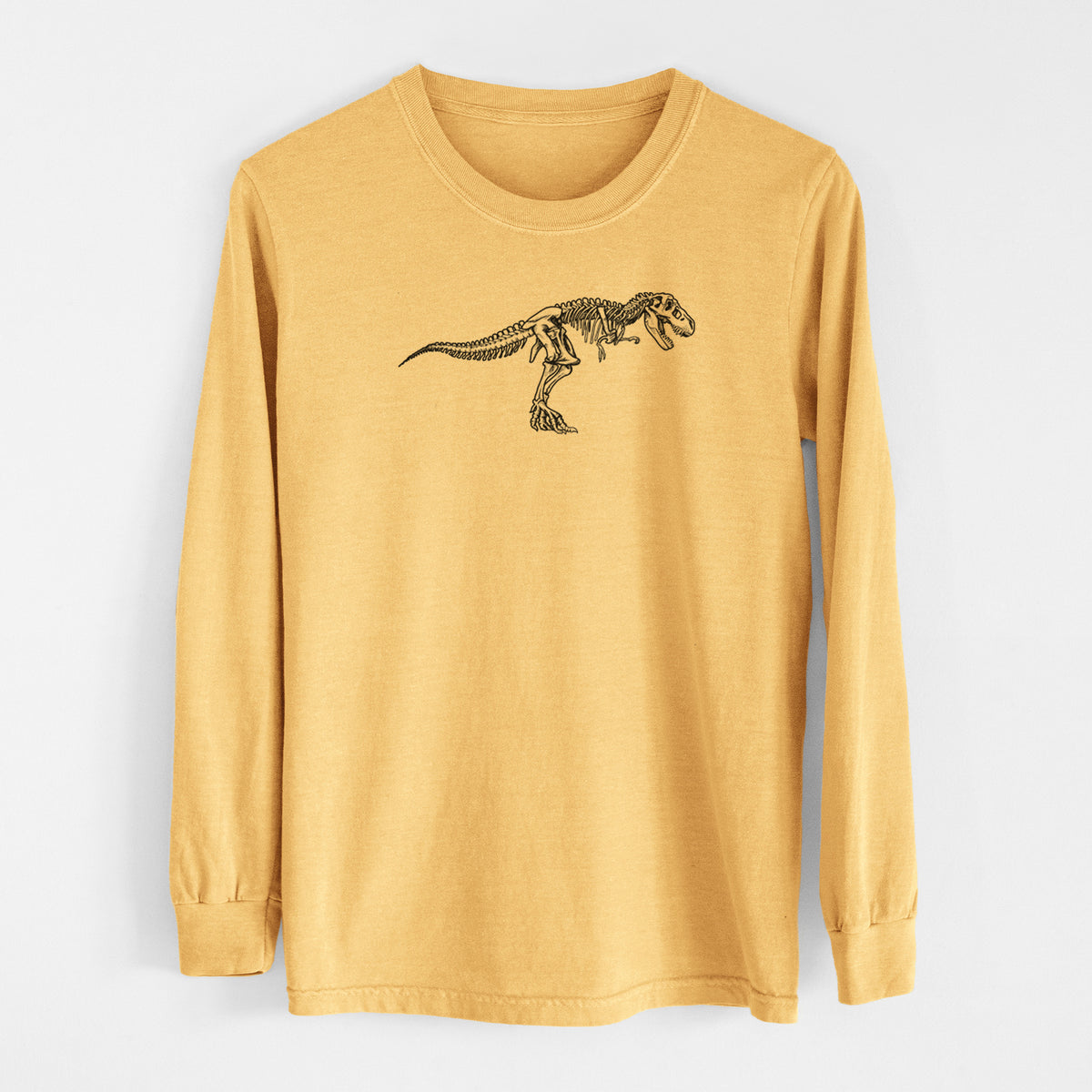 Golden wheat yellow Comfort Colors long sleeve shirt laid flat, printed with a black ink illustration of a Tyrannosaurus rex skeleton.