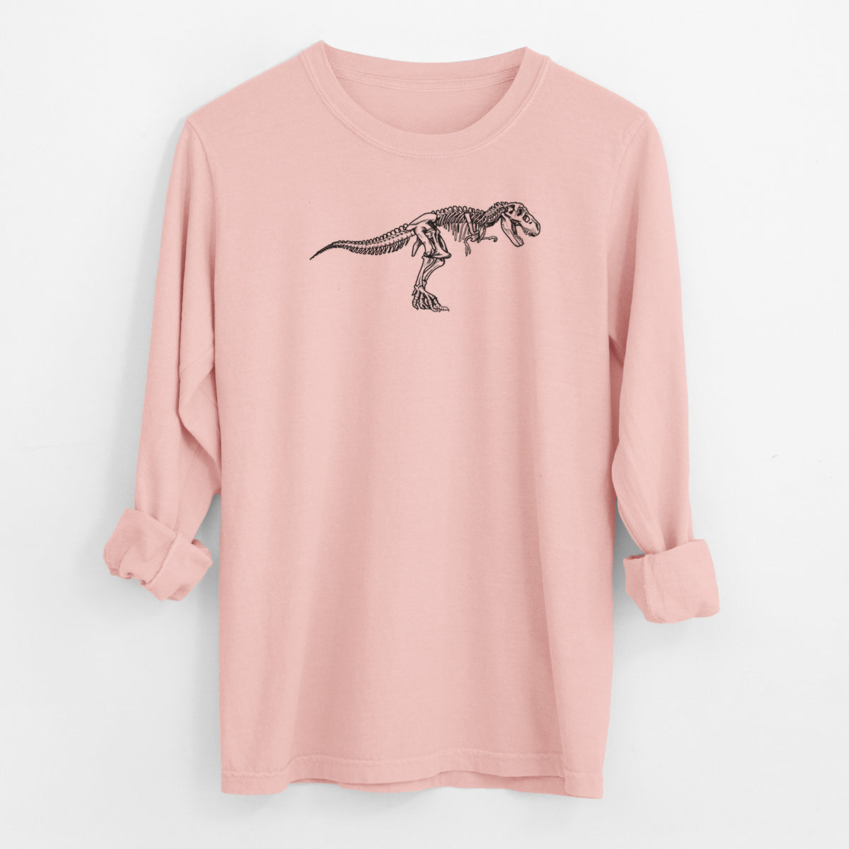Peachy Comfort Colors long sleeve shirt laid flat with the cuffs rolled, printed with a black ink illustration of a Tyrannosaurus rex skeleton.