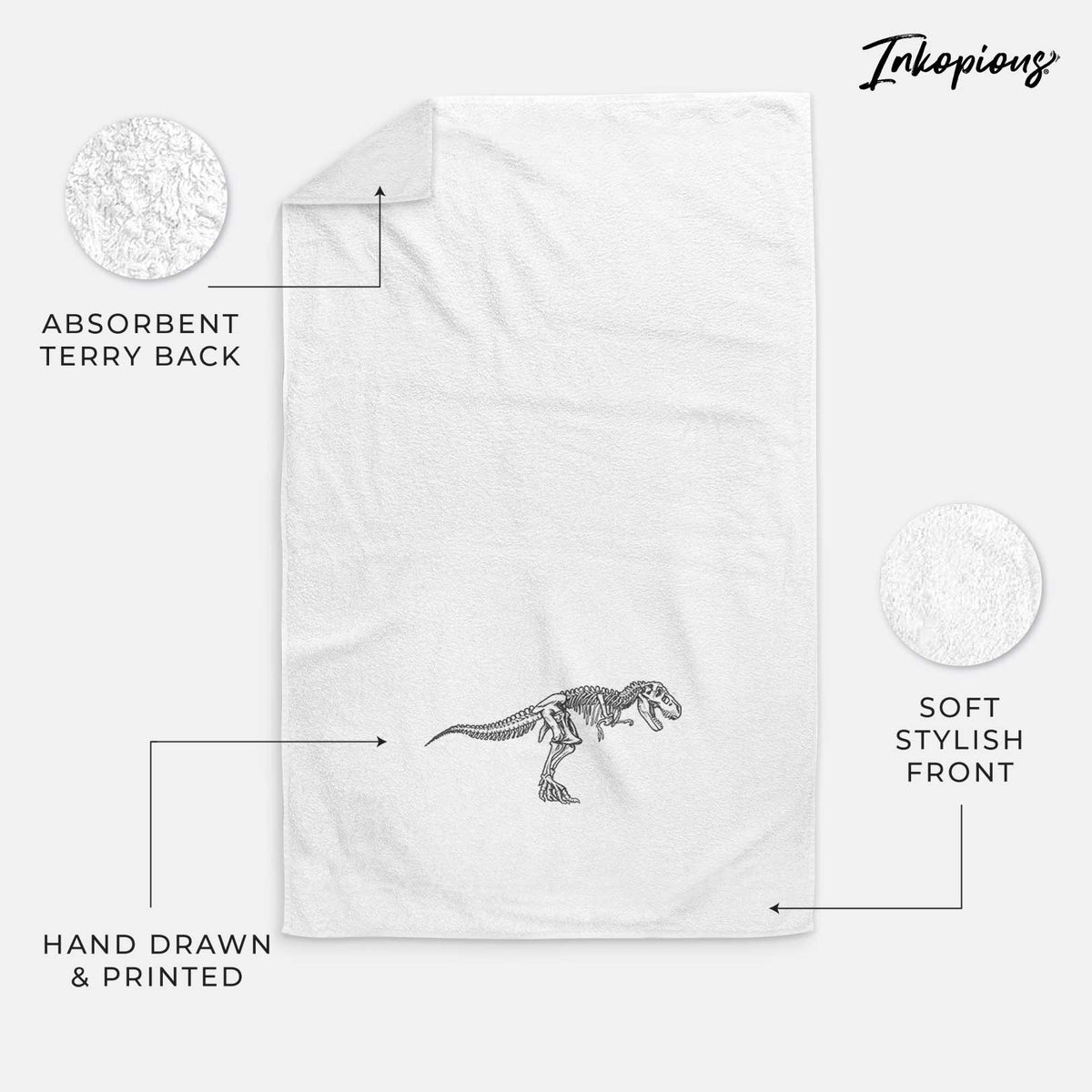 White hand towel printed with a black ink illustration of a Tyrannosaurus rex skeleton.