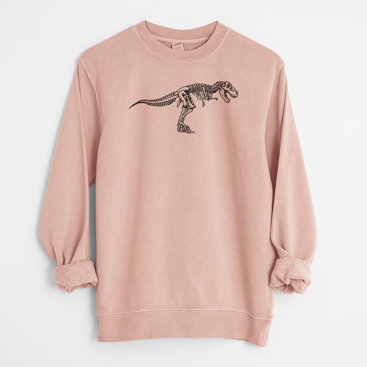 Dusty pink pigment dyed crewneck sweatshirt laid flat with the sleeves rolled, printed with a black ink illustration of a Tyrannosaurus rex skeleton.