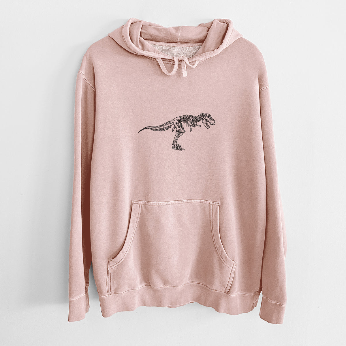 Dusty pink pigment dyed hoodie laid flat, printed with a black ink illustration of a Tyrannosaurus rex skeleton.