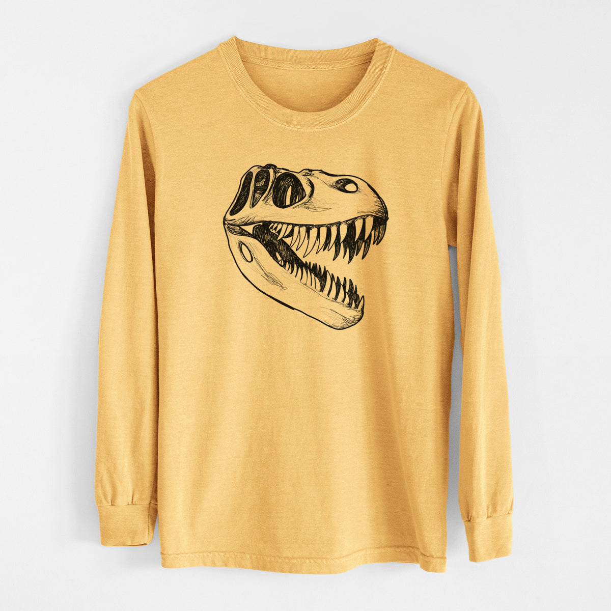 Golden wheat yellow Comfort Colors long sleeve shirt laid flat, printed with a black ink illustration of a Tyrannosaurus rex skull with sharp teeth.
