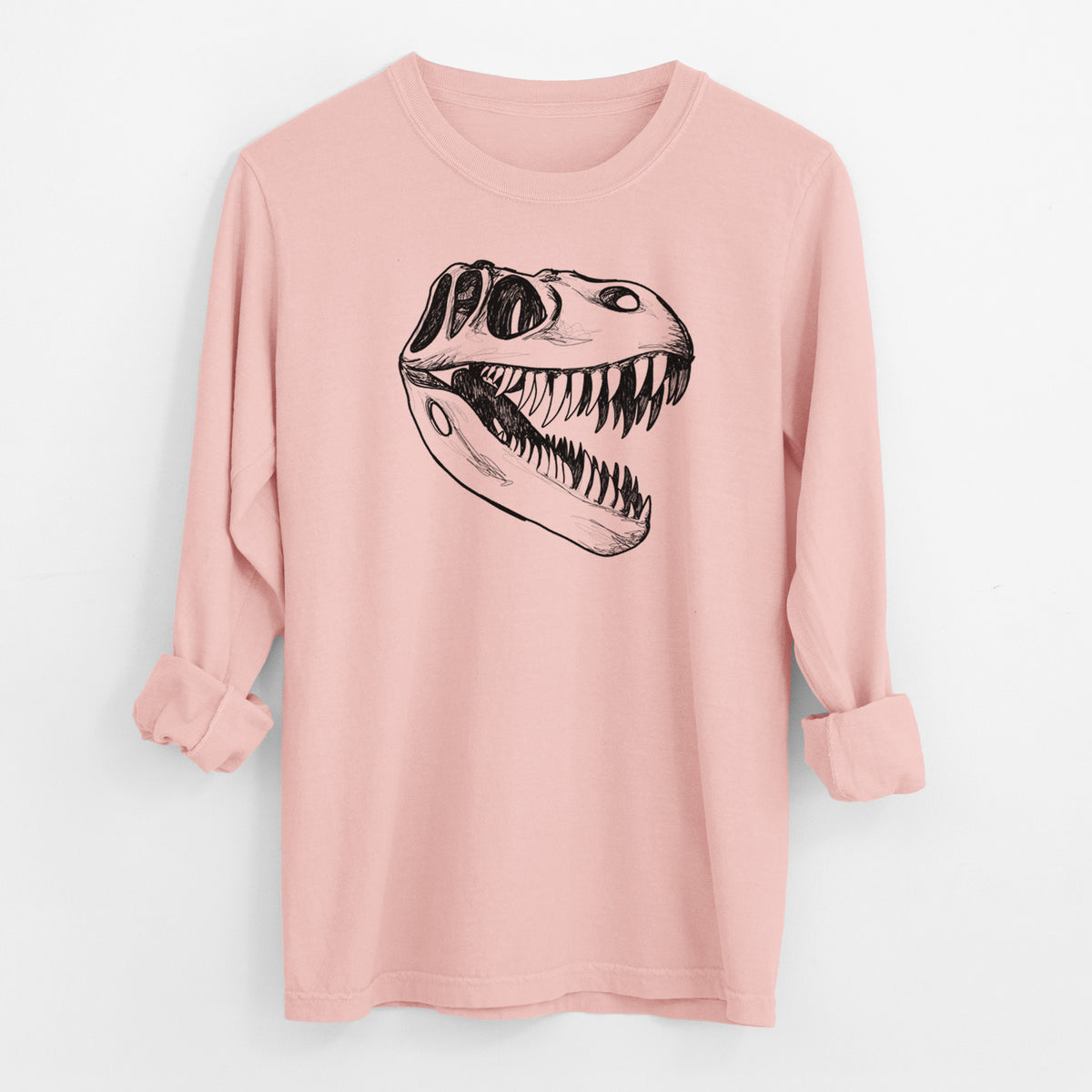 Peachy Comfort Colors long sleeve shirt laid flat with the cuffs rolled, printed with a black ink illustration of a Tyrannosaurus rex skull with sharp teeth.