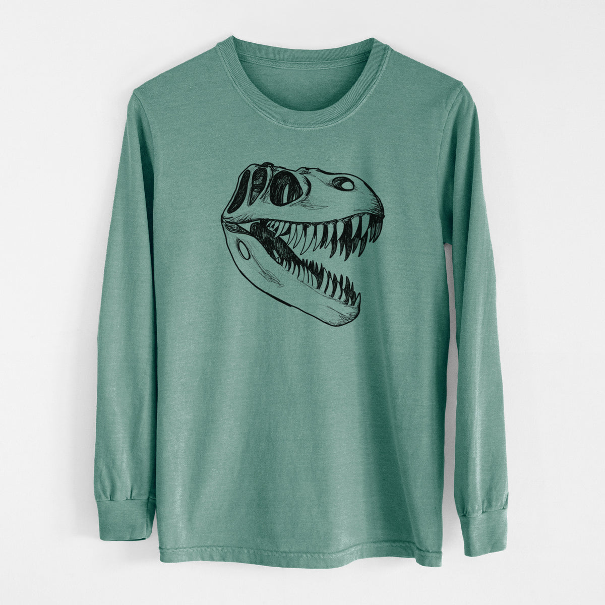 Pine green Comfort Colors long sleeve shirt laid flat, printed with a black ink illustration of a Tyrannosaurus rex skull with sharp teeth.