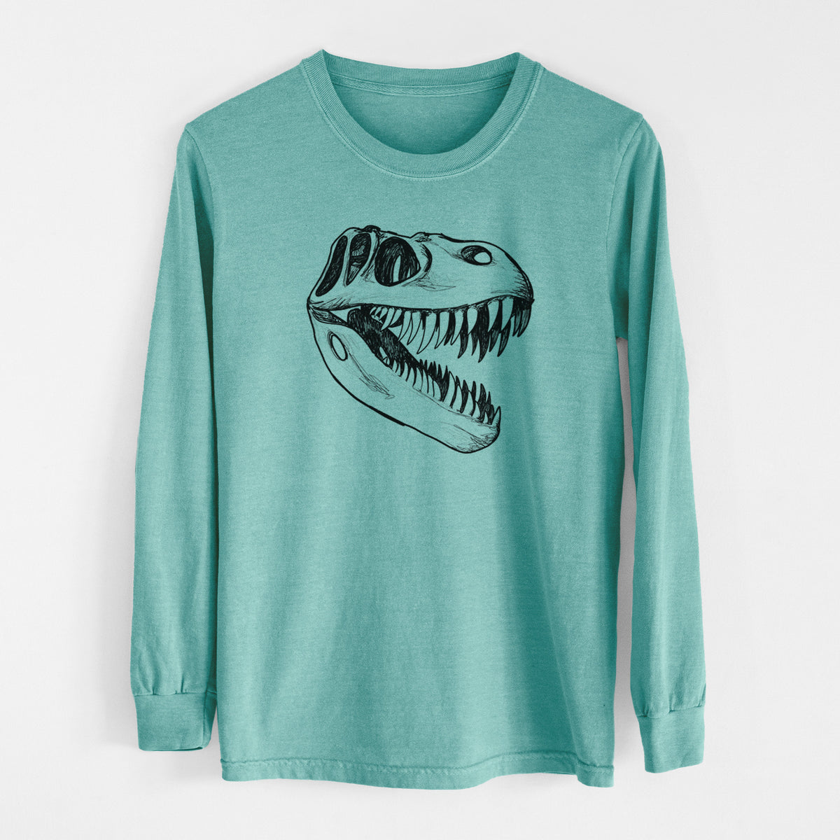 Reef green Comfort Colors long sleeve shirt laid flat, printed with a black ink illustration of a Tyrannosaurus rex skull with sharp teeth.