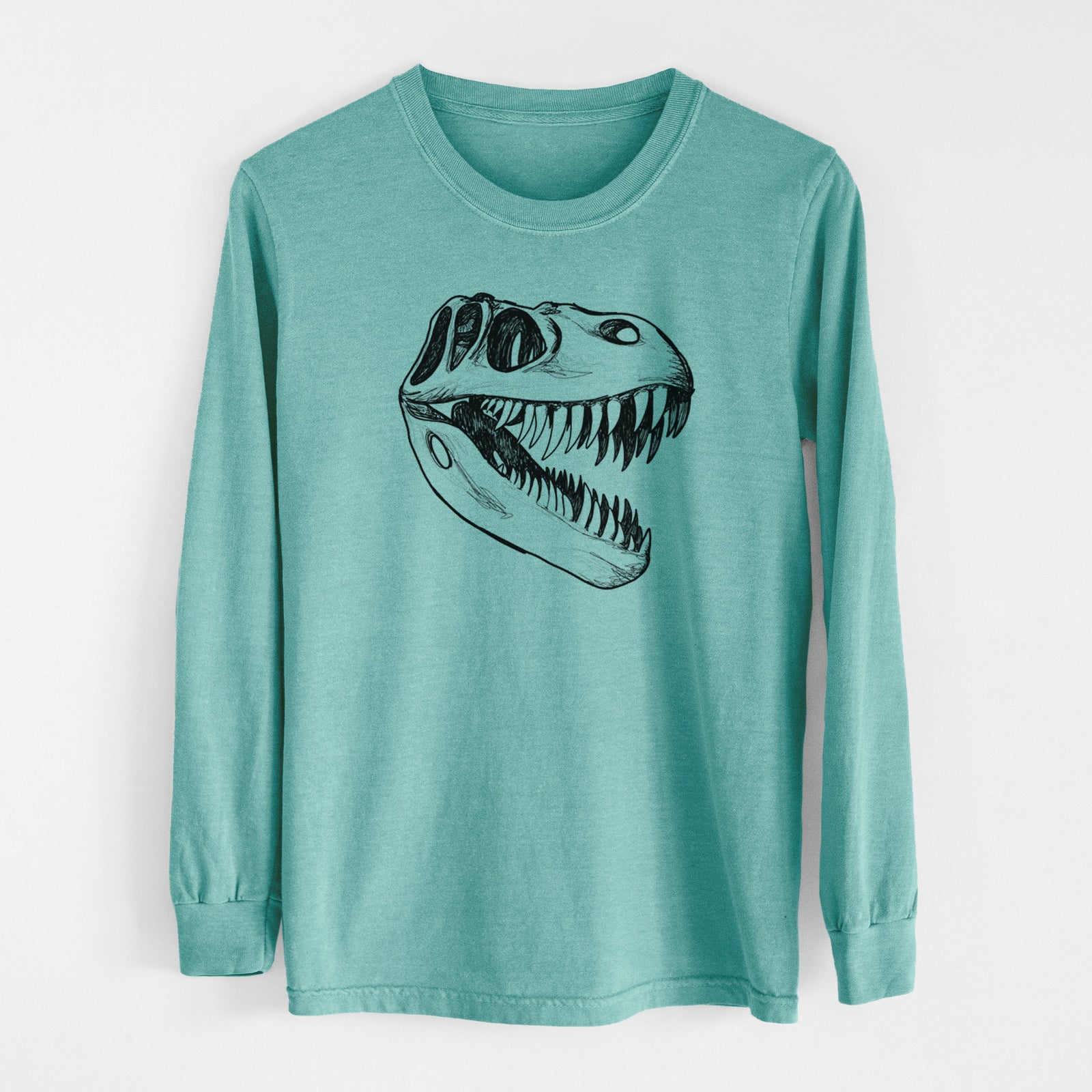 Reef green Comfort Colors long sleeve shirt laid flat, printed with a black ink illustration of a Tyrannosaurus rex skull with sharp teeth.