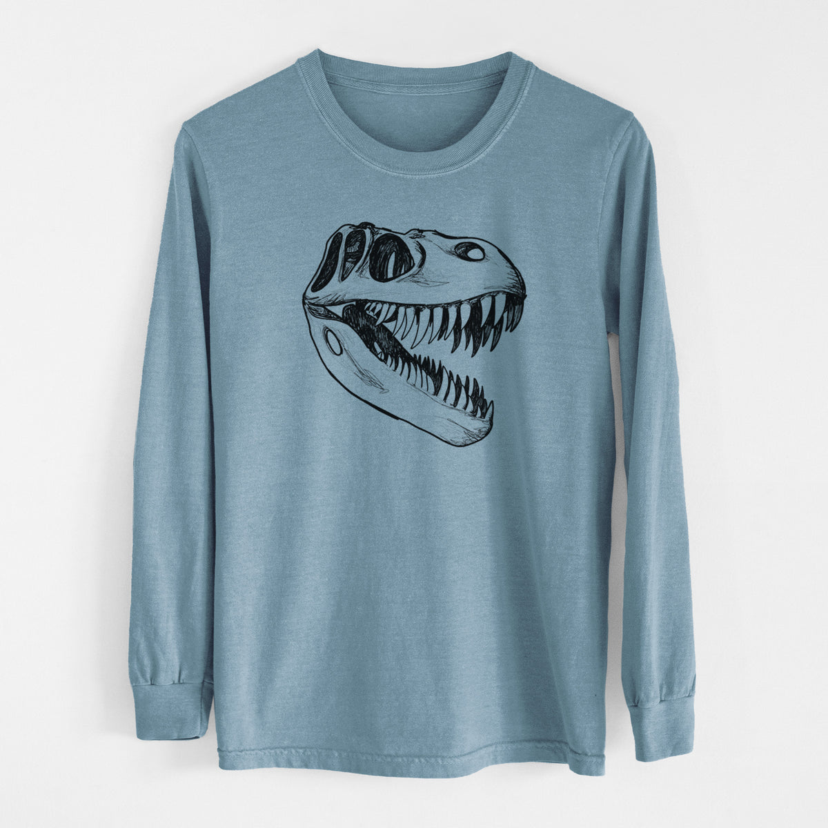 Steel blue Comfort Colors long sleeve shirt laid flat, printed with a black ink illustration of a Tyrannosaurus rex skull with sharp teeth.
