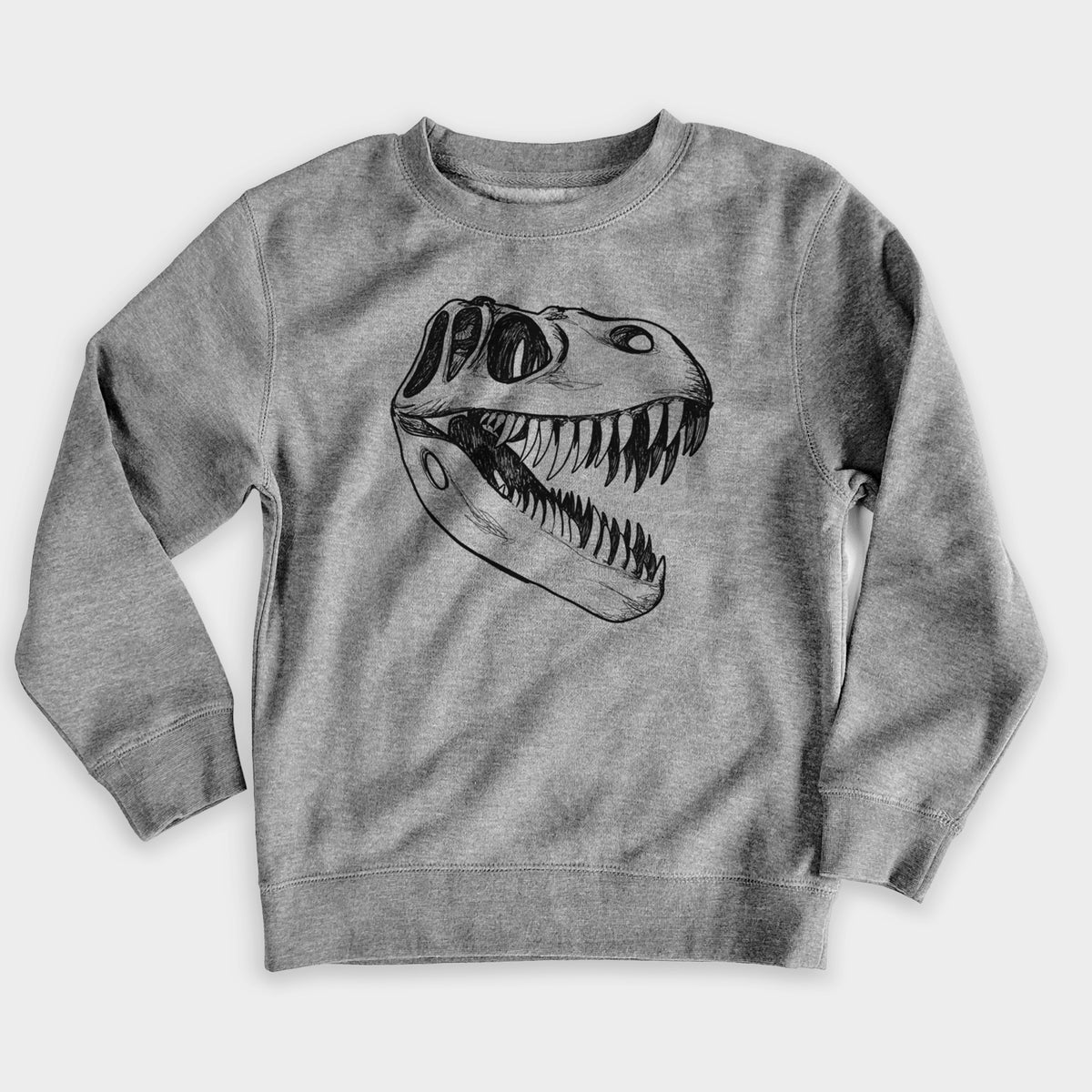 Nickel grey youth crewneck sweatshirt laid flat, printed with a black ink illustration of a Tyrannosaurus rex skull with sharp teeth.