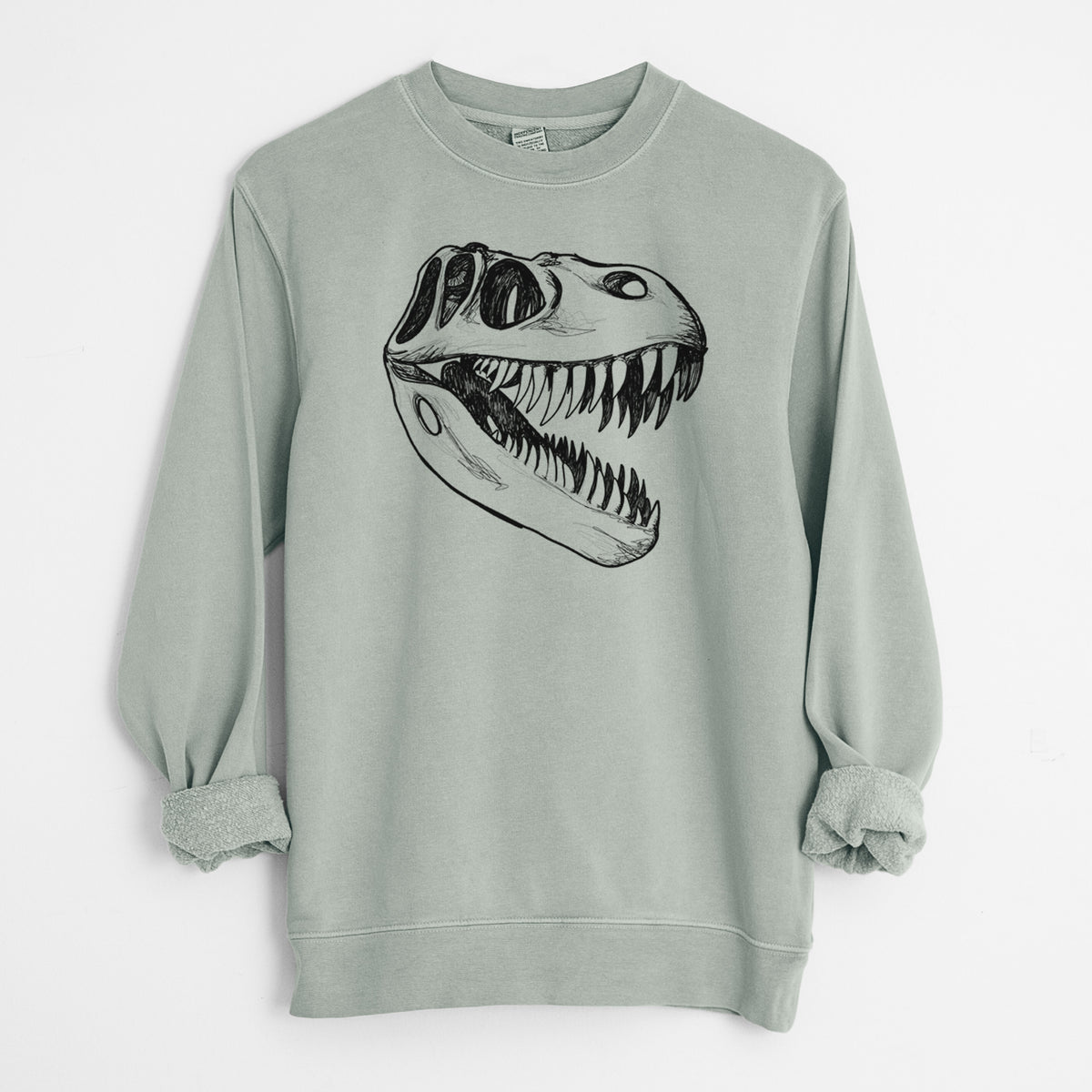 Sage green pigment dyed crewneck sweatshirt laid flat with the sleeves rolled, printed with a black ink illustration of a Tyrannosaurus rex skull with sharp teeth.
