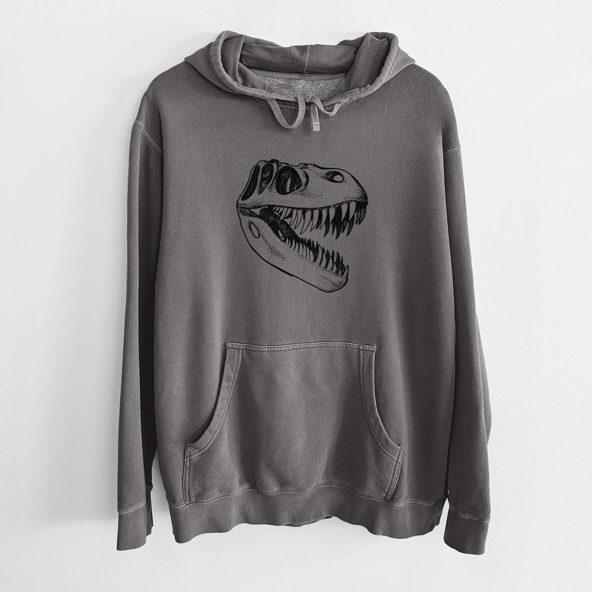 Faded black pigment dyed hoodie laid flat, printed with a black ink illustration of a Tyrannosaurus rex skull with sharp teeth.