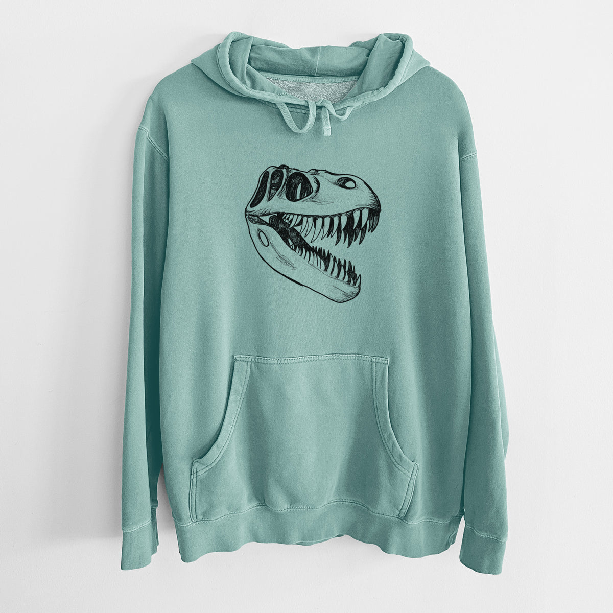 Mint green pigment dyed hoodie laid flat, printed with a black ink illustration of a Tyrannosaurus rex skull with sharp teeth.