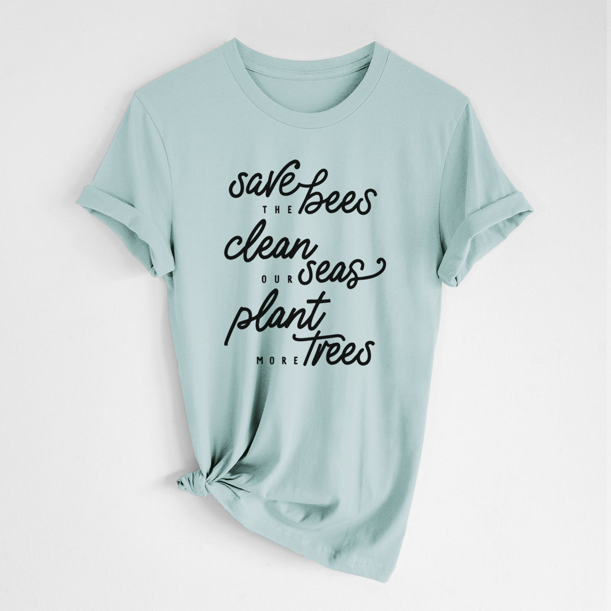 Dusty blue lightweight cotton t-shirt laid flat with the sleeves rolled, printed with black hand-lettered words reading Save the Bees, Clean Our Seas, Plant More Trees.