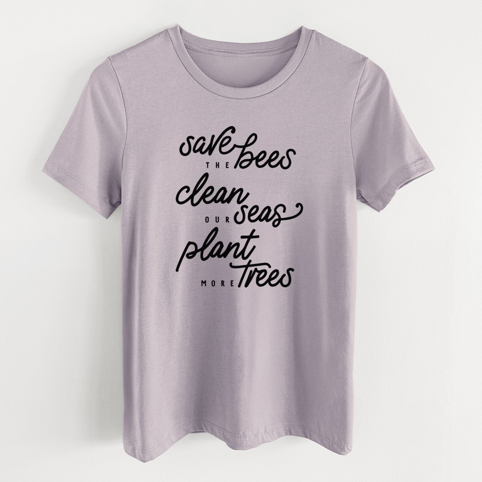 Light violet women's relaxed fit cotton t-shirt laid flat, printed with black hand-lettered words reading Save the Bees, Clean Our Seas, Plant More Trees.